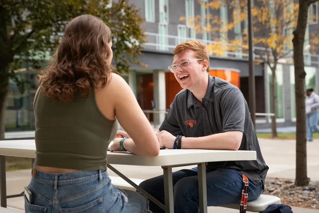 Students sitting on a bench outside.